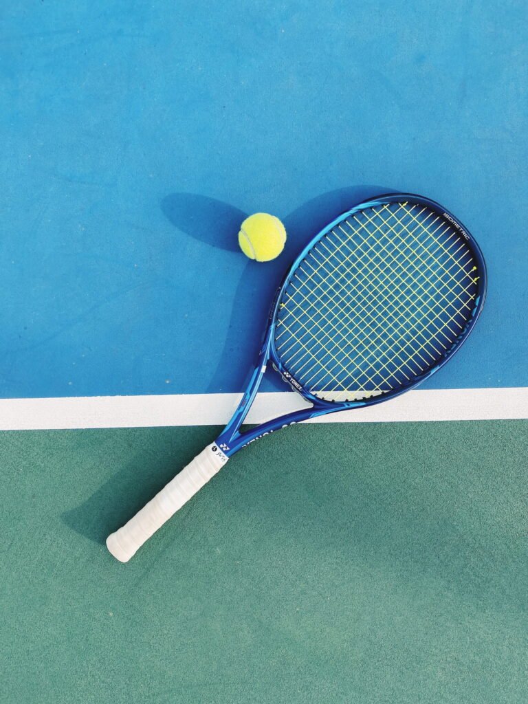 Tennis racket on the ground with tennis ball