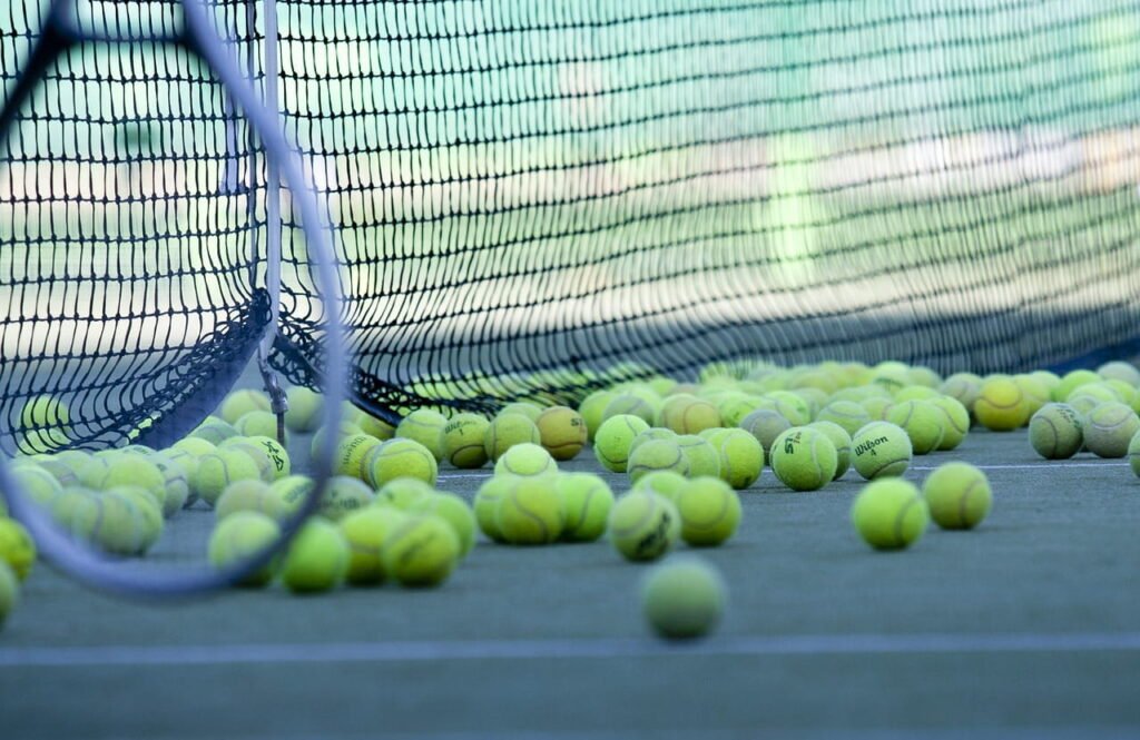 Many tennis balls on the tennis court.