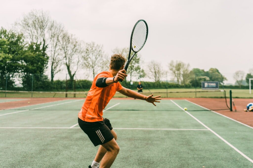 Man setting up to hit tennis ball on the court