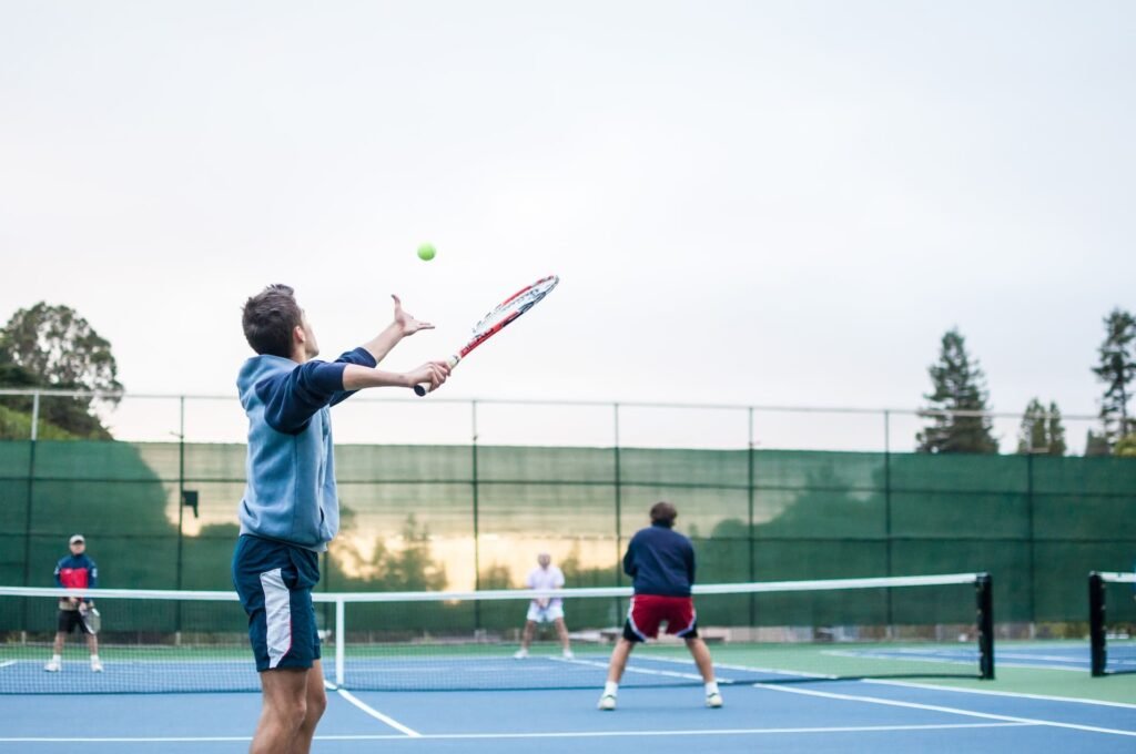 Man about to serve a Tennis ball during a game