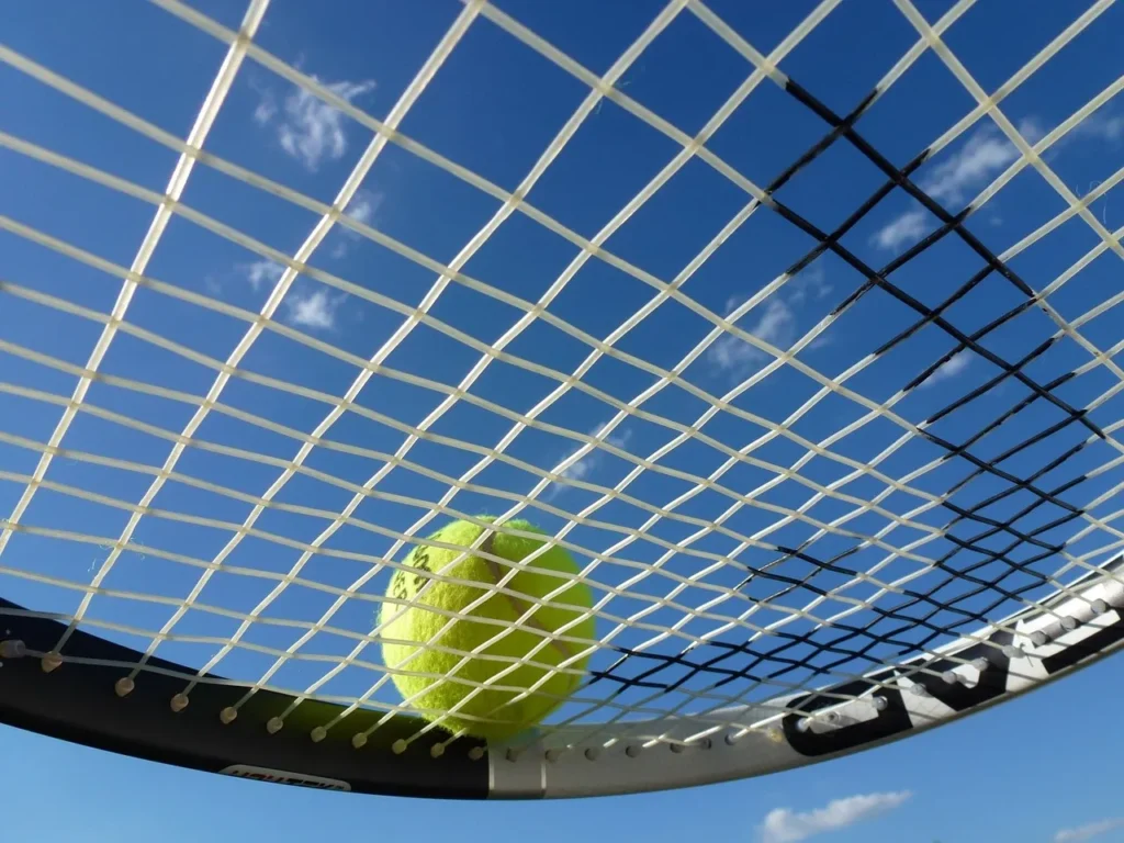 Tennis racket string close up with tennis ball on it